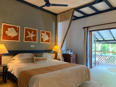 Camera accogliente con letto grande, luce calda e balcone con vista sul mare.