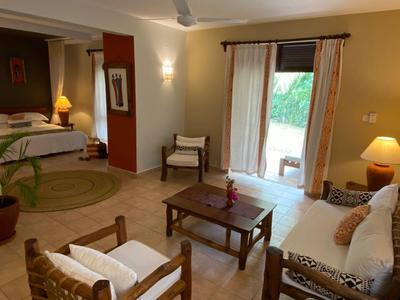 Soggiorno accogliente con divano, sedie, tavolo e accesso a camera da letto e terrazza.