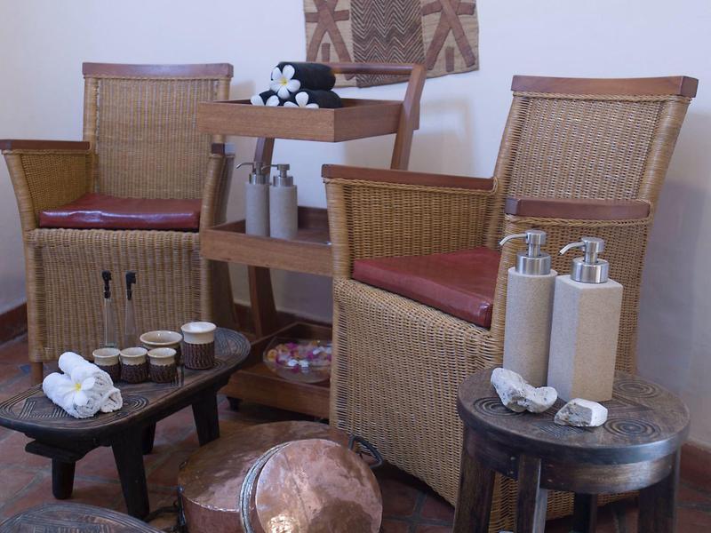 Area spa accogliente con due sedie, asciugamani e decorazioni.