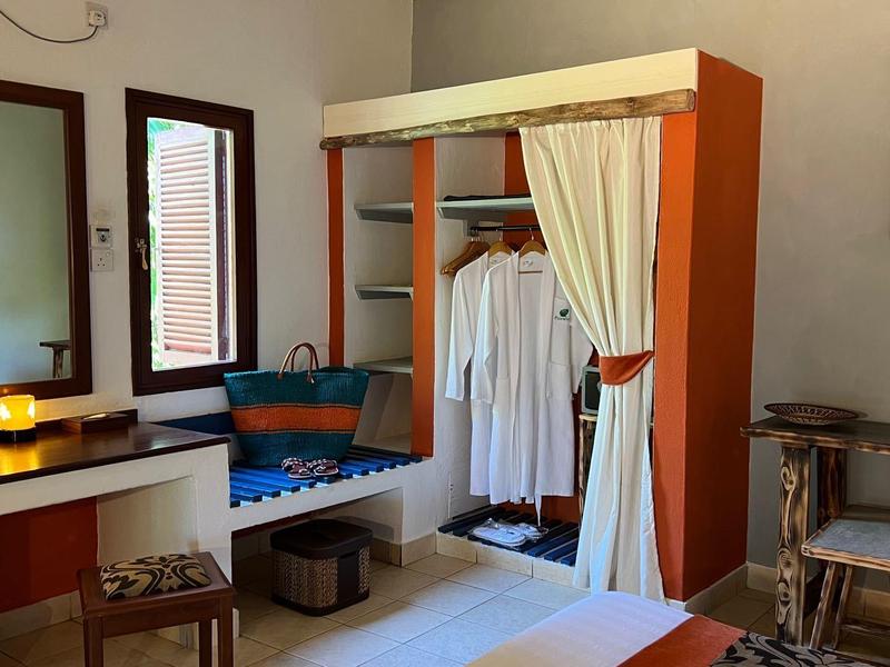 Camera d'hotel accogliente con scrivania piccola, armadio e area salotto.