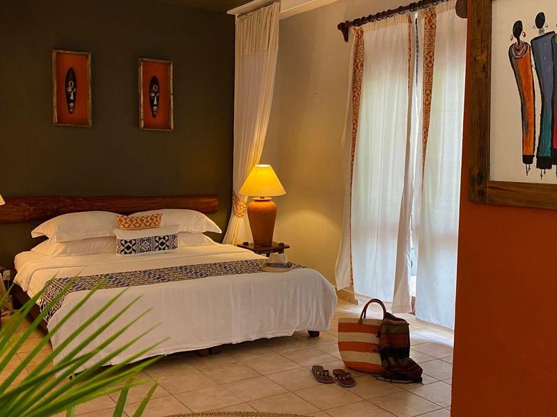 Camera accogliente con letto matrimoniale, due comodini e luce calda.