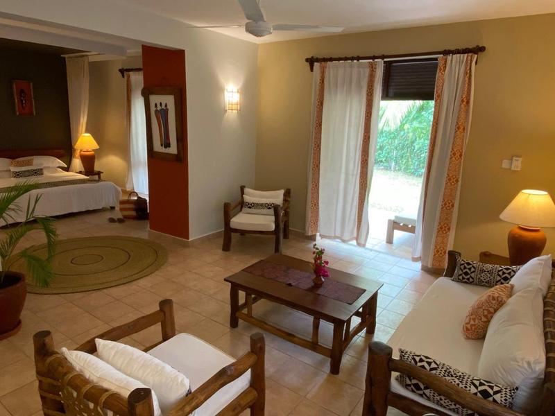 Soggiorno accogliente con divano, sedie, tavolo e accesso a camera da letto e terrazza.