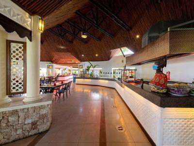 Innenraum eines modernen Hotelrestaurants mit Holzdach und verschiedenen Sitzbereichen.