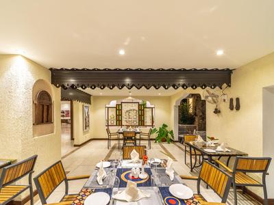 Großer Hotel-Speisesaal mit Holzdach, vielen Tischen und Stühlen und natürlichem Licht durch Fenster.