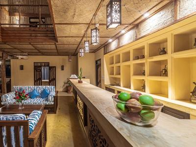 Innenraum einer stilvollen Hotellounge mit langem Tresen und gemütlicher Sitzgruppe.