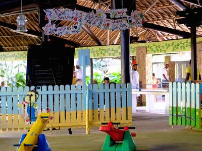 Barevná dětská herna s houpačkami a skluzavkami pod dřevěnou střechou