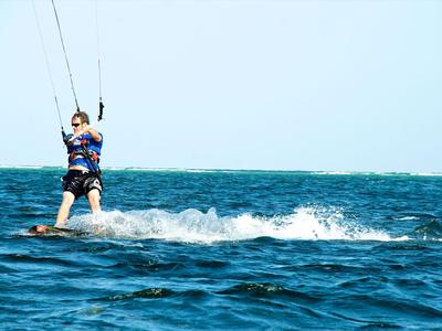 Person beim Kitesurfen auf dem Meer bei klarem Himmel