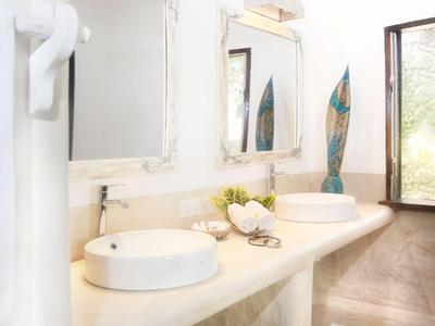 Heller Hotelbadezimmerbereich mit zwei runden Waschbecken und großem Spiegel.