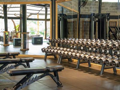 Moderner Fitnessraum mit Hanteln, Spiegeln und Trainingsbank in einem Hotel.