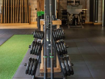 Dumbbell-Regal mit verschiedenen Hanteln in einem modernen Fitnessbereich eines Hotels.