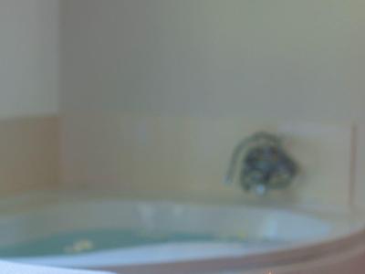 Bain à remous relaxant avec bougies chauffe-plat allumées et décoration sur un plateau.