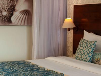 Cozy double bed with blue bedspread and books on the bed in a hotel room.