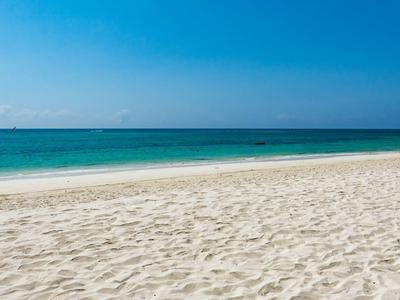 wide sandy beach with clear blue sea and blue sky