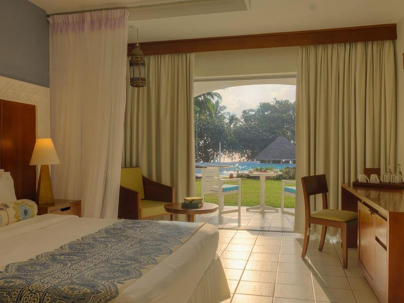 Cozy hotel room with double bed, desk, and garden view.