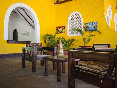 Gemütliche Sitzecke mit Holzmöbeln und gelb gestrichenen Wänden in einem Hotel oder Ferienhaus.