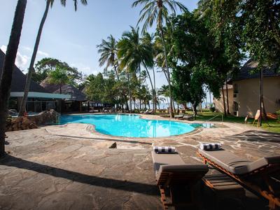 Área de piscina en resort tropical con tumbonas y palmeras