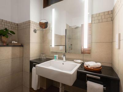 Modernes Badezimmer mit Waschbecken, Spiegel und Handtüchern in einem Hotelzimmer.