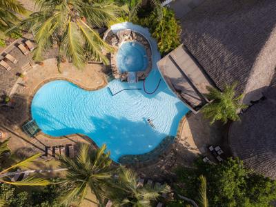 Luftaufnahme eines verschlungenen Pools umgeben von Palmen und Liegestühlen in einem tropischen Resort.