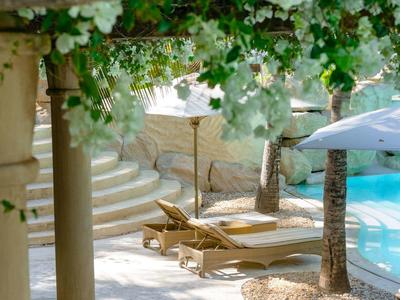 Chambre d'hôtel lumineuse avec grand lit, meubles en bois et porte ouverte sur le jardin