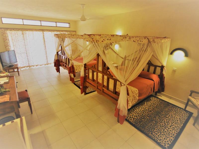 Habitación doble luminosa con camas dosel y acceso a un balcón en el hotel.