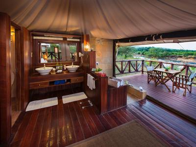 Luxuriöses Badezimmer mit Holzboden, moderner Einrichtung und Terrasse mit Blick ins Grüne.