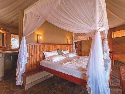 Chambre de lodge avec lit à baldaquin et décoration en bois naturel.