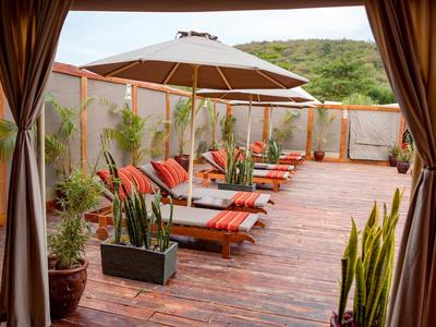 Terrace with lounge chairs, sun umbrella, and plants, relaxing and inviting area