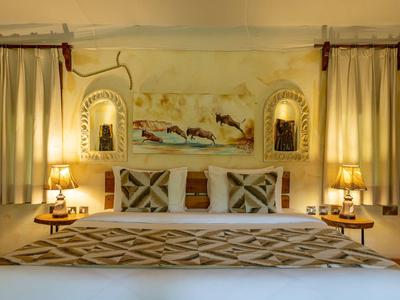 Cozy hotel room with decorative bed, curtains, and soft lighting.