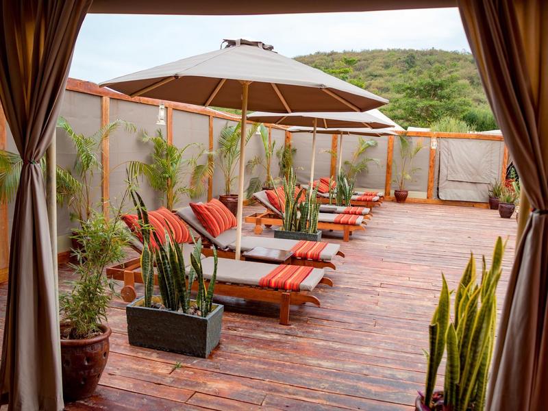 Terrace with lounge chairs, sun umbrella, and plants, relaxing and inviting area