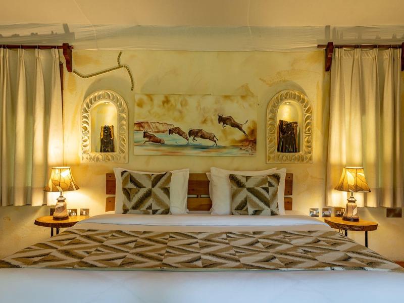 Cozy hotel room with decorative bed, curtains, and soft lighting.