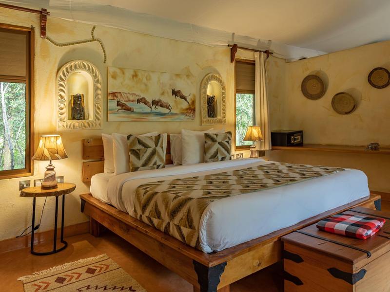 Cozy hotel room with large bed, warm wooden furniture, and stylish wall decor.