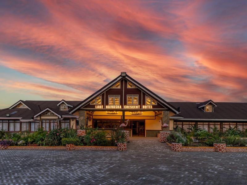Modern hotel building under a dramatic sunset with an orange sky.
