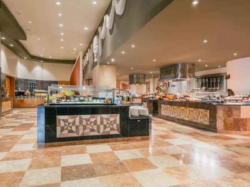 Buffet elegante con colores de mármol, cueva y luces de techo en un restaurante moderno de hotel.