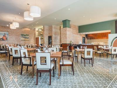 Modernes, helles Restaurant mit Holztischen und bequemen Stühlen im Hotelambiente.
