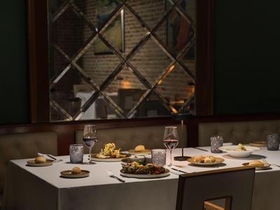 Eleganter gedeckter Tisch mit Speisen und Weingläsern in einem stilvollen Restaurant.