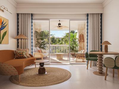 Helles Hotelzimmer mit Gartenblick, modernem Mobiliar und Terrasse mit Stühlen und Pflanzen.