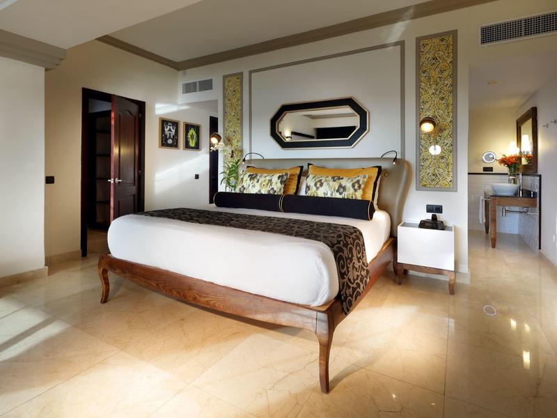 Habitación de hotel moderna con cama doble grande y diseño elegante.