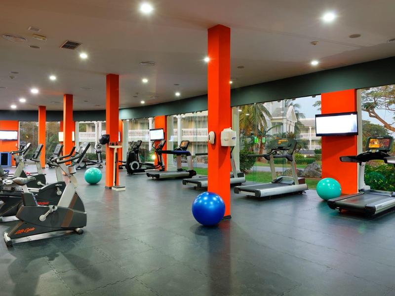Gimnasio moderno en el hotel con varios equipos de entrenamiento y pelotas de gimnasia de colores.