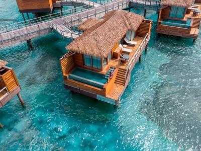 Water bungalow with pool over clear turquoise water and connected walkways