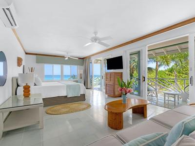 Modern eingerichtete Hotel-Suite mit Terrasse und Blick auf das Wasser.