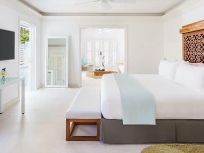 Helles Hotelzimmer mit großem Bett, weißen Wänden und modernen Möbeln.