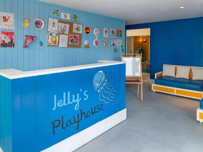 Heller Empfangsbereich mit blauem Tresen und bunter Kinderkunst an der Wand.