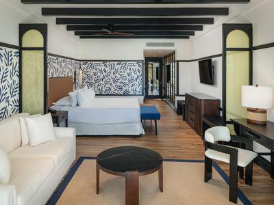 Geräumiges Hotelzimmer mit Bett, Sofa, Schreibtisch und modernem Dekor.