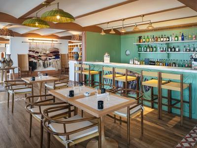 Helles, modernes Café mit Holzmöbeln und grüner Wand hinter der Theke