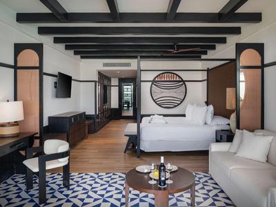 Modern eingerichtetes Hotelzimmer mit Doppelbett, Sofa und stilvollen Möbeln.