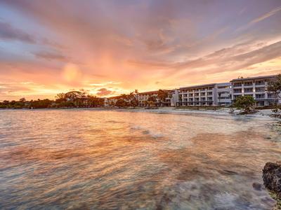 Hotel am Ufer mit ruhigem Wasser und farbenprächtigem Sonnenuntergang.
