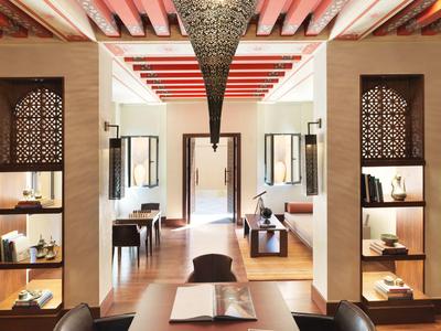 Luxury hotel lobby with wooden shelves, warm lighting, and intricate ceiling design.