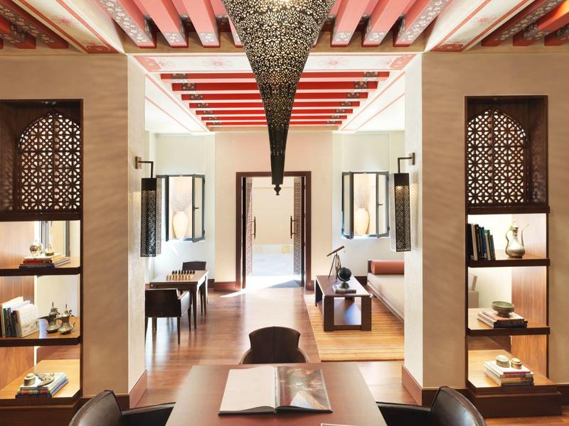 Luxury hotel lobby with wooden shelves, warm lighting, and intricate ceiling design.