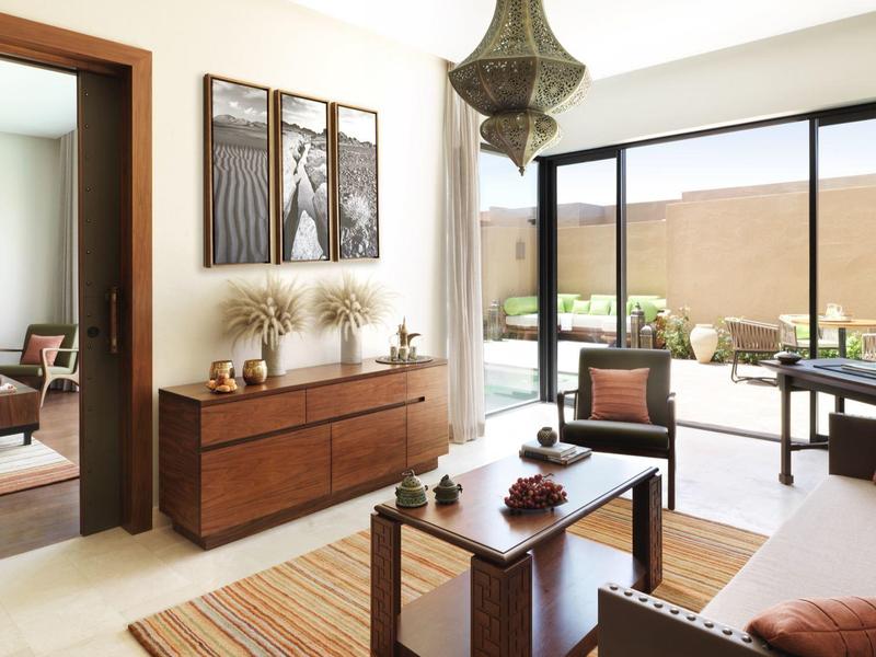 Bright living area with wooden furniture and sliding glass doors overlooking a terrace.
