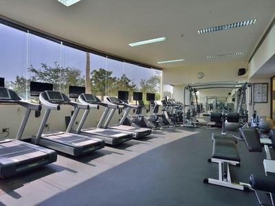 Modernes Fitnessstudio mit Laufbändern und Trainingsgeräten, große Fenster bieten Ausblick.